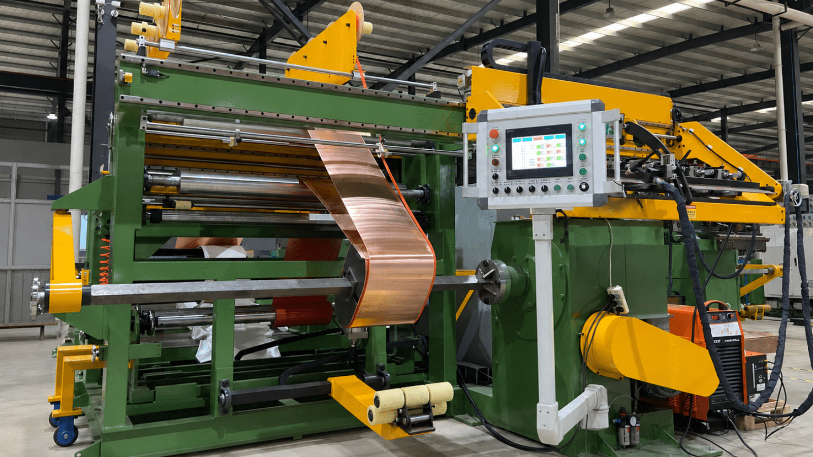 Transformer foil winding machine for producing high quality low voltage coil assemblies