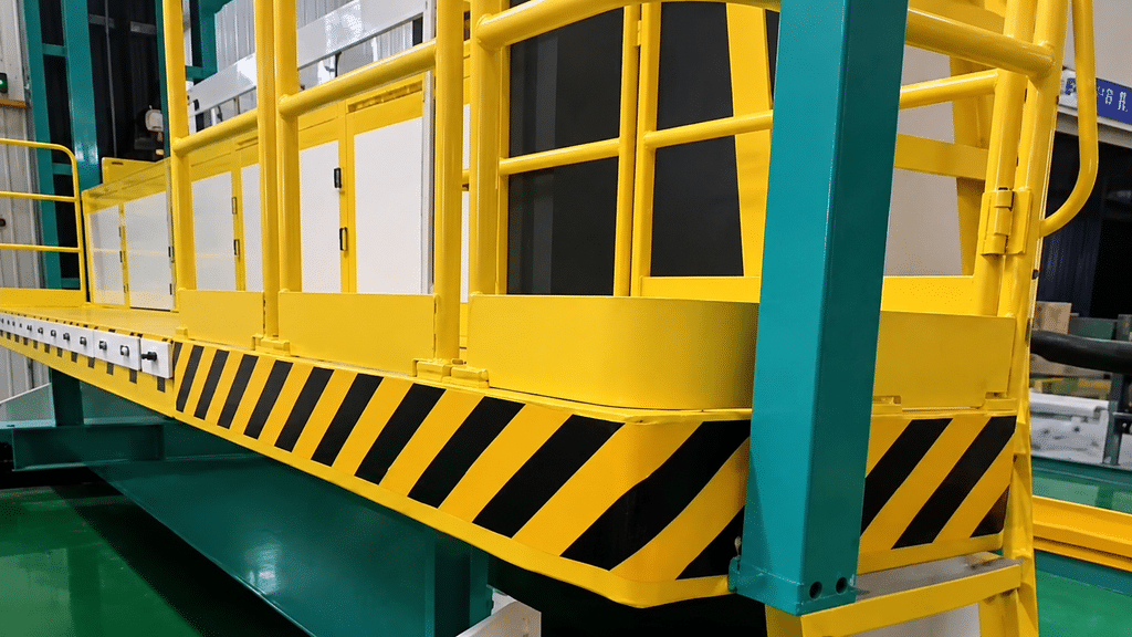 Another angle of the yellow platform deck with striped safety markings and surrounding railings