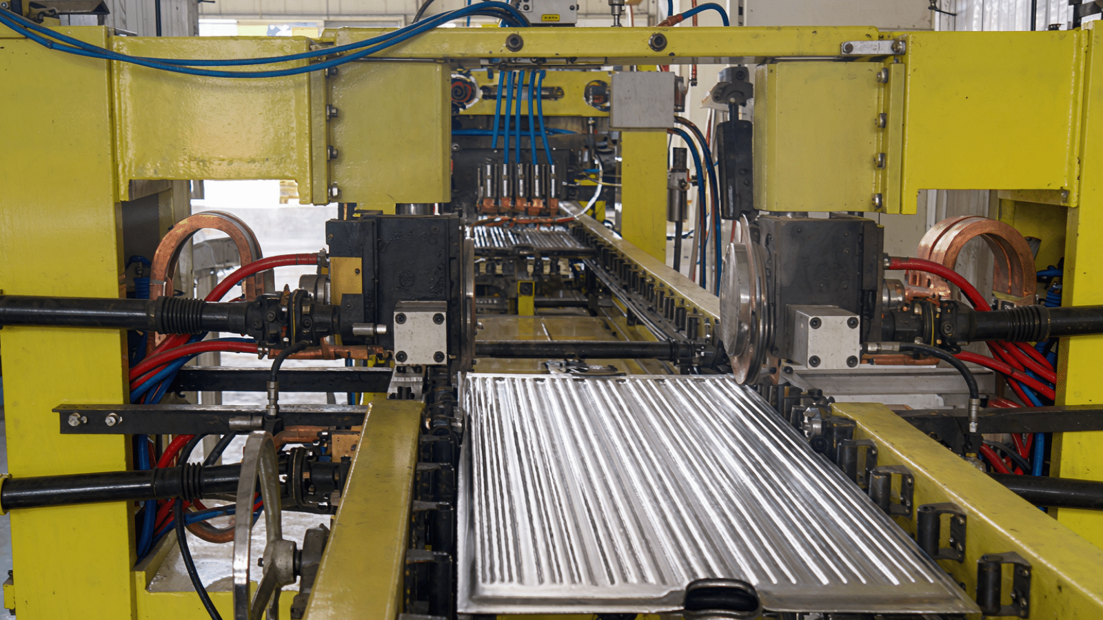A formed radiator fin passing through the gantry multi-spot welding station of the automatic production line