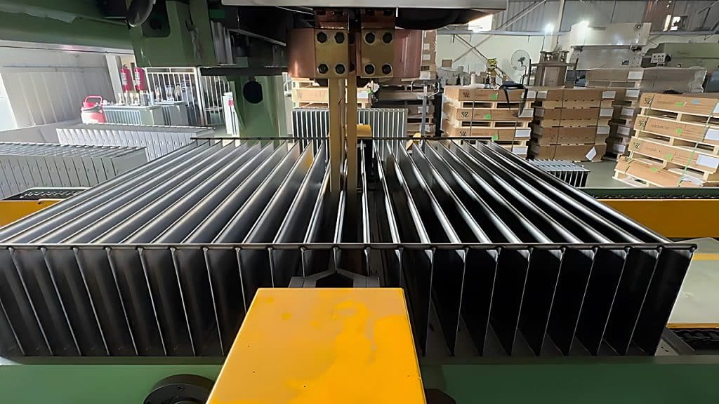 The spot welding station pressing reinforcing ribs onto a formed corrugated fin