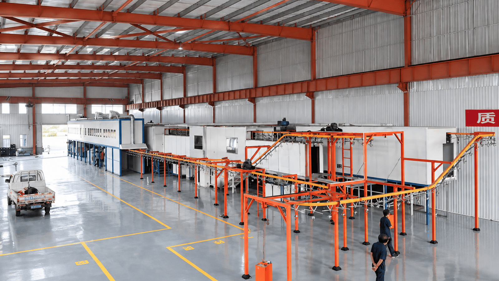 Installed industrial painting line in a factory workshop, with spray booths and overhead conveyor