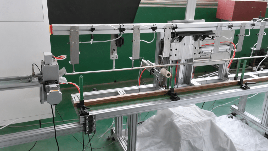 Pressboard strip clamped on the infeed rail of a rolling and chamfering station configured as a separate line